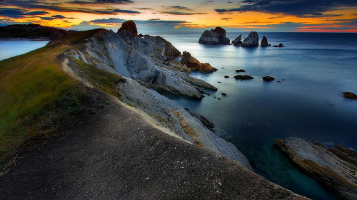 Sunset Coast and Rocks in Water